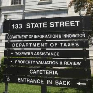 Daytime view of the Department of Taxes sign outside the Vermont State House in Montpelier