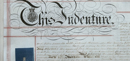 Close up view of an old contract with illustrated letters spelling out This Indenture