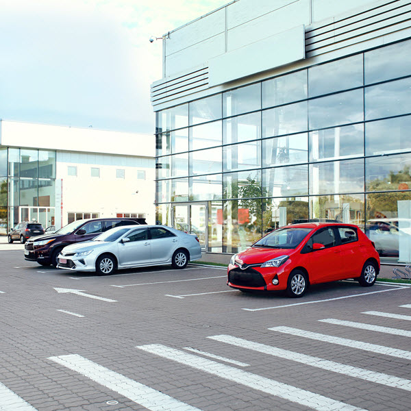 Daytime view of an auto dealership with three cars parked outside